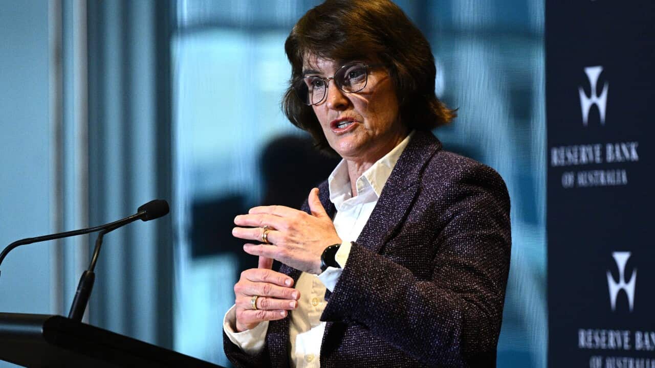 Reserve bank governor Michele Bullock in a grey blazer in front of a blue background