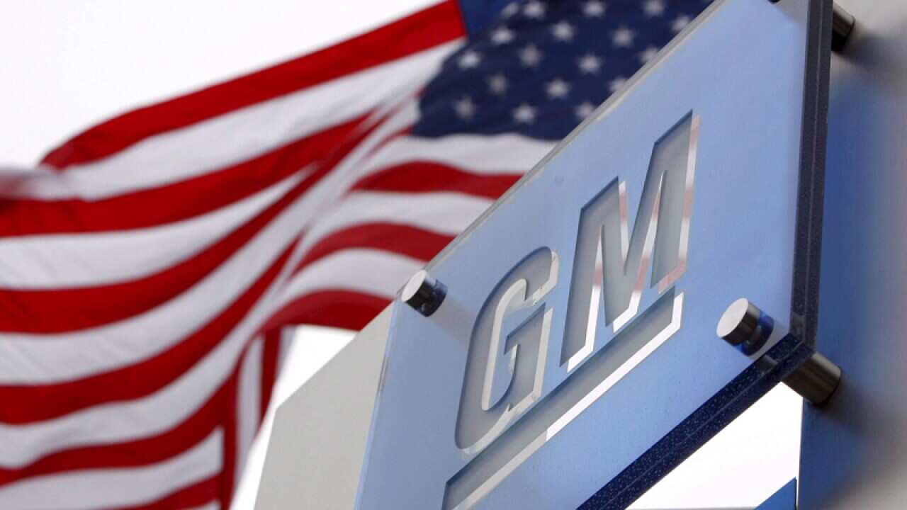 Stock photo of an American flag and GM logo