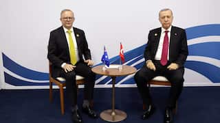 Australian Prime Minister Anthony Albanese and Turkish President Recep Tayyip Erdogan sitting beside each other at a small round table. The Australian and Tyrkish