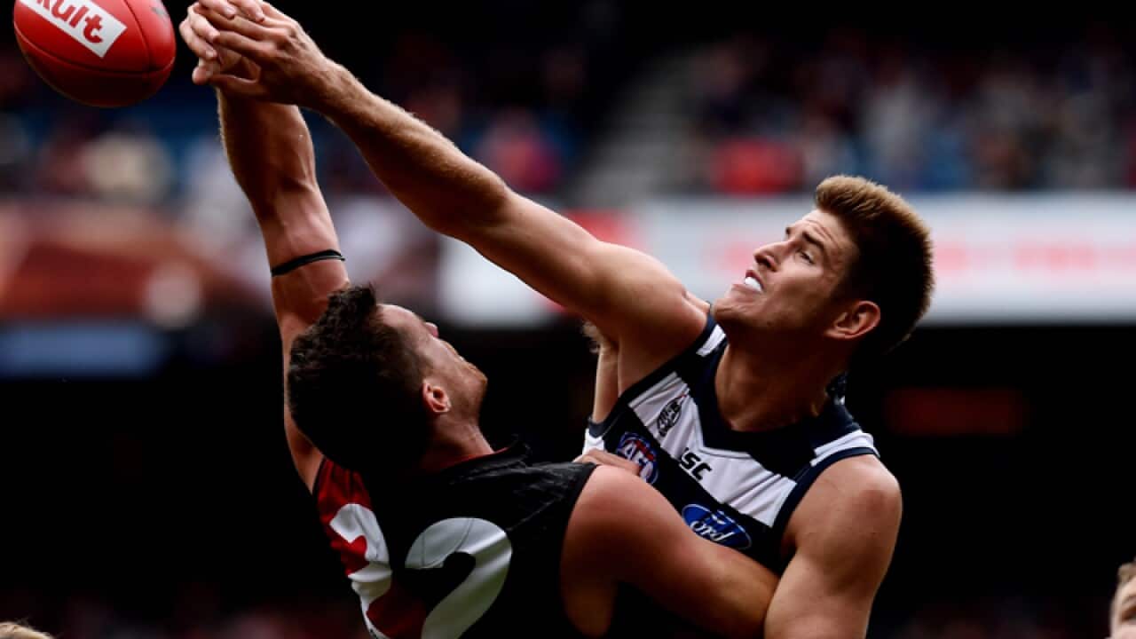 Zac Smith of the Cats hits the ball away from Matthew Leuenberger