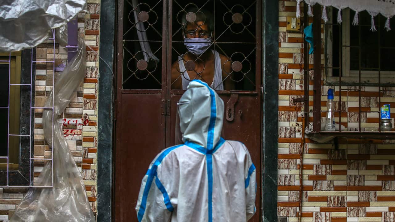 An Indian health worker talks to a resident in Mumbai.