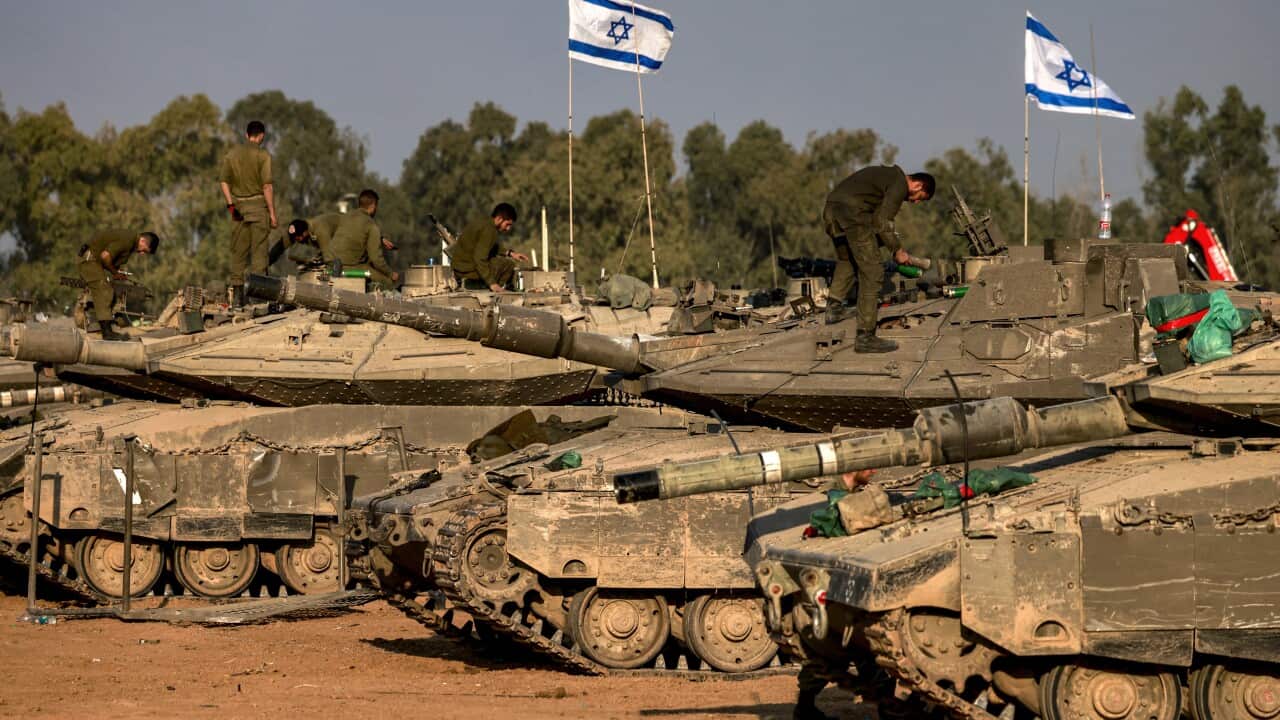 Israeli battle tanks are deployed at a position along the border with the Gaza Strip.