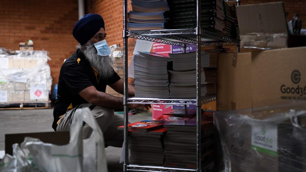 A Turbans 4 Australia volunteer sorts through donated books for children in Sydney during the pandemic