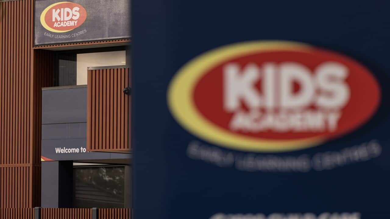 An entrance of a childcare centre with a red oval logo and the words “KIDS ACADEMY“