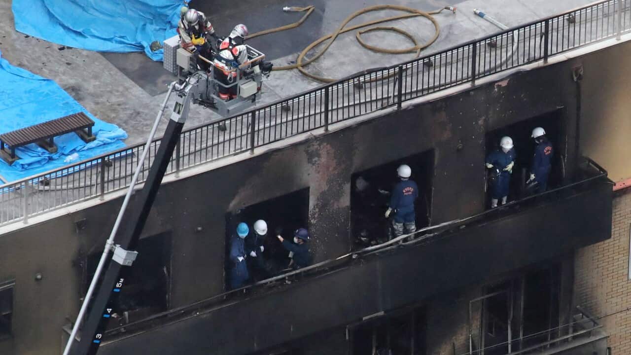 Kyoto police officers investigate at a three-story Kyoto Animation building, where a man set fire with liquid to kill 33 people and injure 35, in Kyoto.