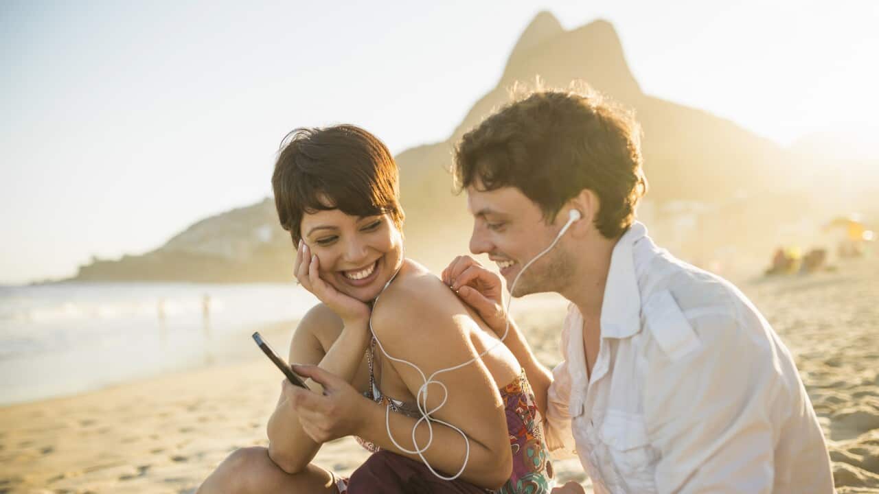 Young couple listening to music, Ipanema Beach, Rio, Brazil