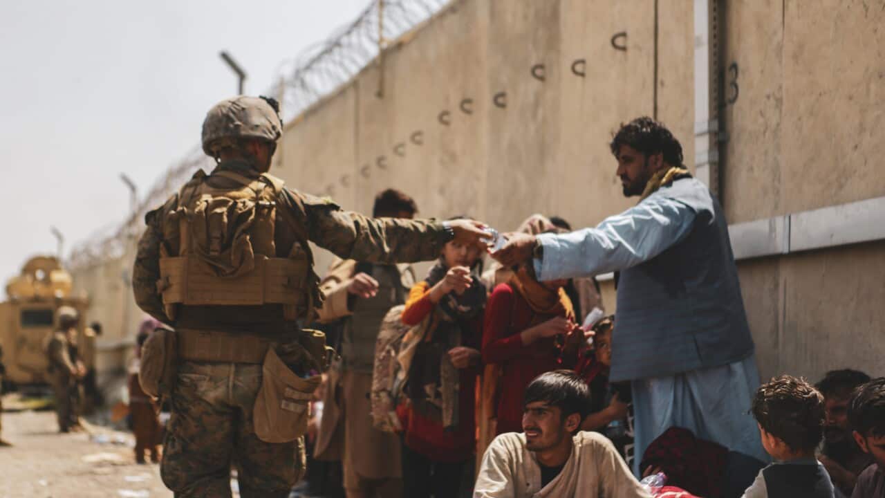 210822-M-TU241-1007 HAMID KARZAI INTERNATIONAL AIRPORT, Afghanistan (August 22, 2021 via Sipa USA) A Marine with the 24th Marine Expeditionary unit (MEU via Sipa USA) passes out water to evacuees during an evacuation at Hamid Karzai International Airport,