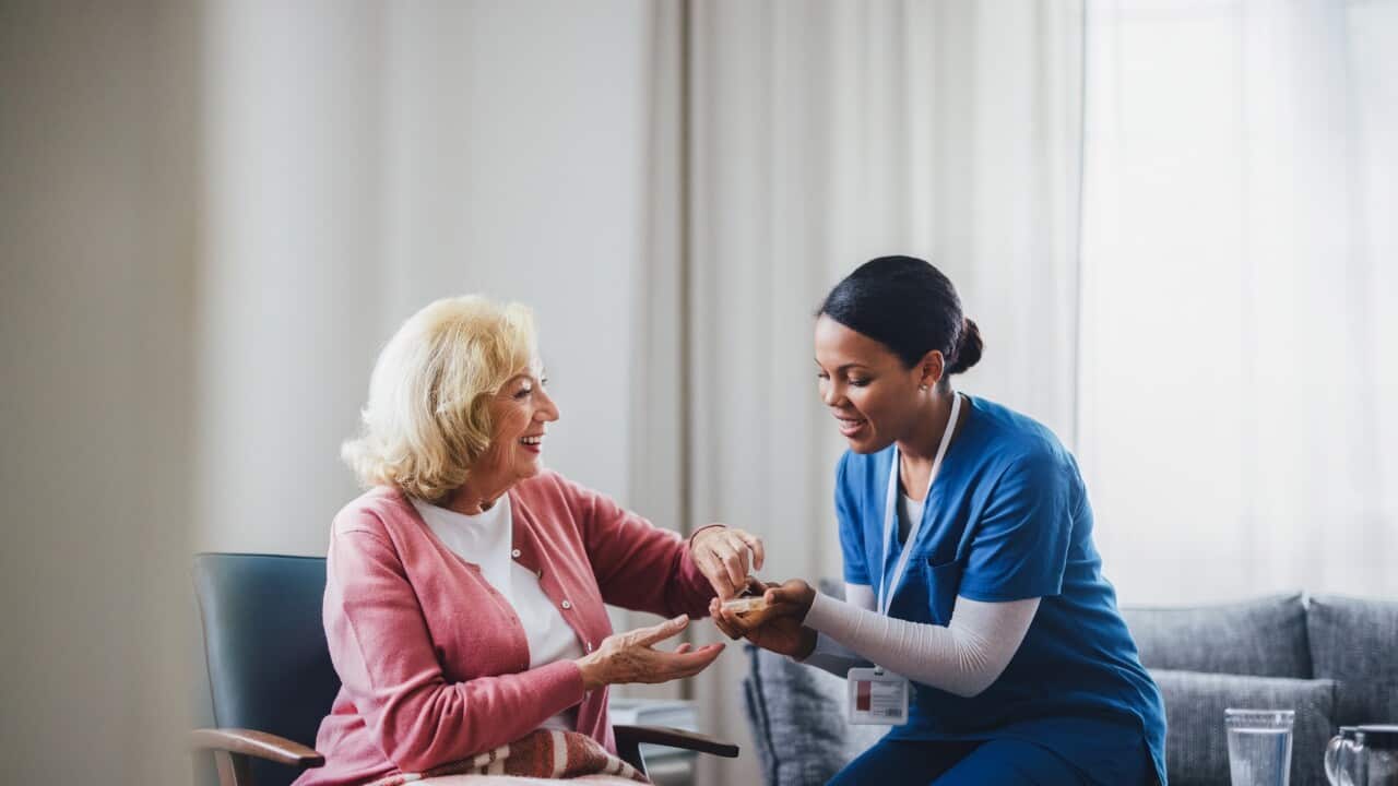 Healthcare Worker Assisting Elderly Woman in Comfortable Home Environment