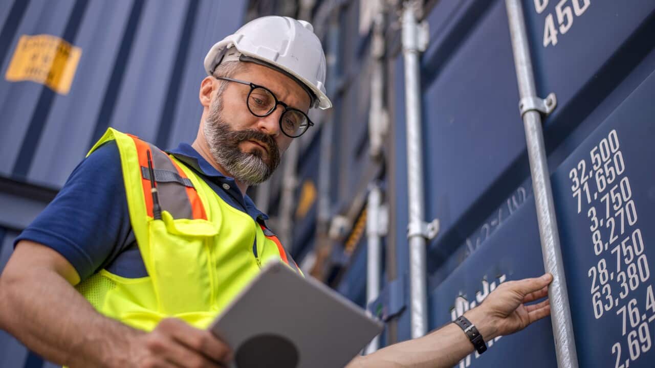 Smart creative foreman engineer man control loading containers box from cargo freight ship for import export. Logistic, transportation, import and export concept with copy space.