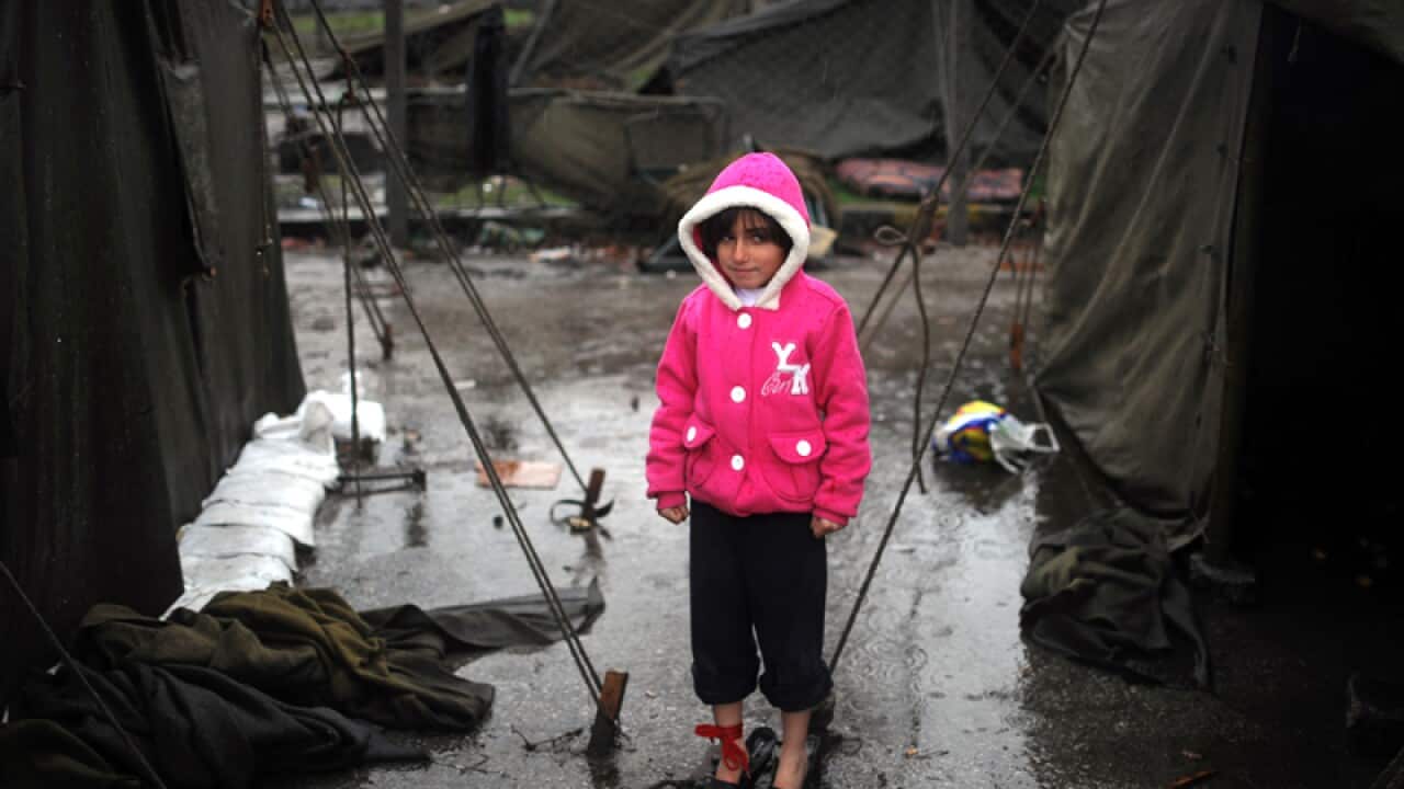 A Syrian girl stands by tents in a refugee camp in Bulgaria