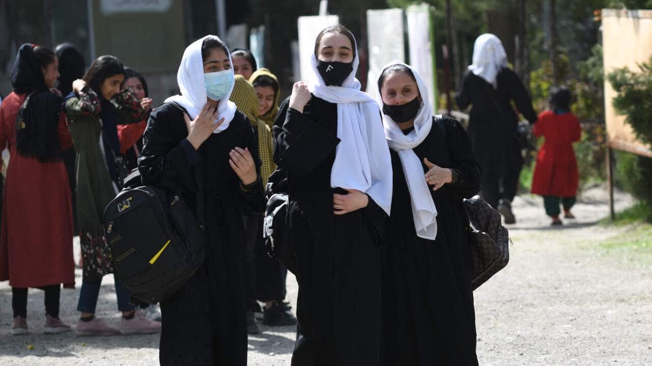 A group of girls are seen walking as the leave school.