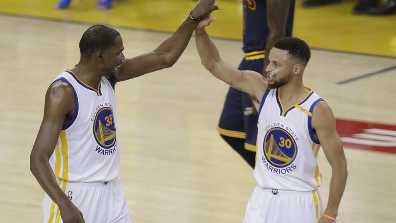 Golden State Warriors players Kevin Durant (L) and Stephen Curry