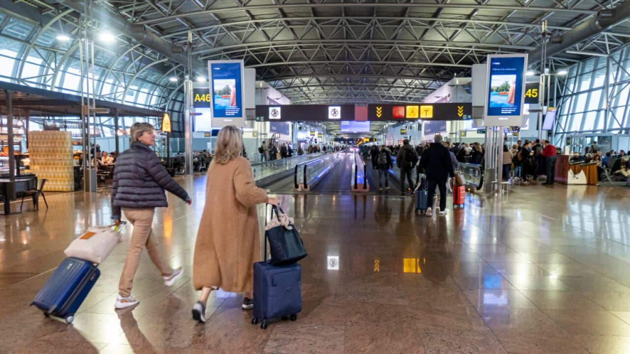 People with bags in an airport terminal