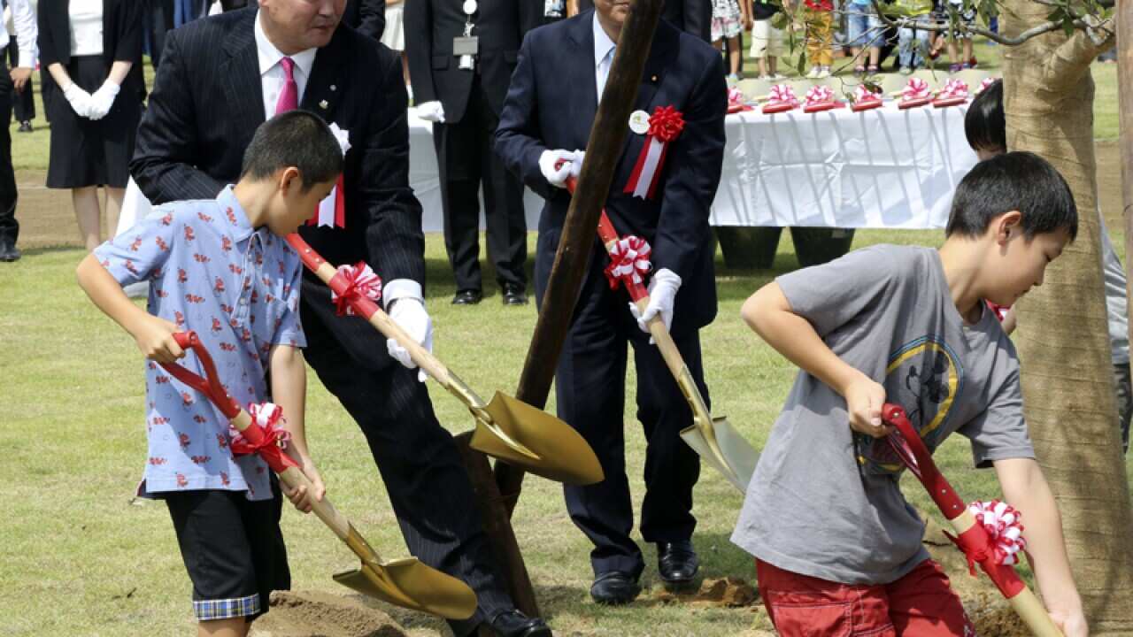Noraha Mayor Yukiei Matsumoto plants a tree with children