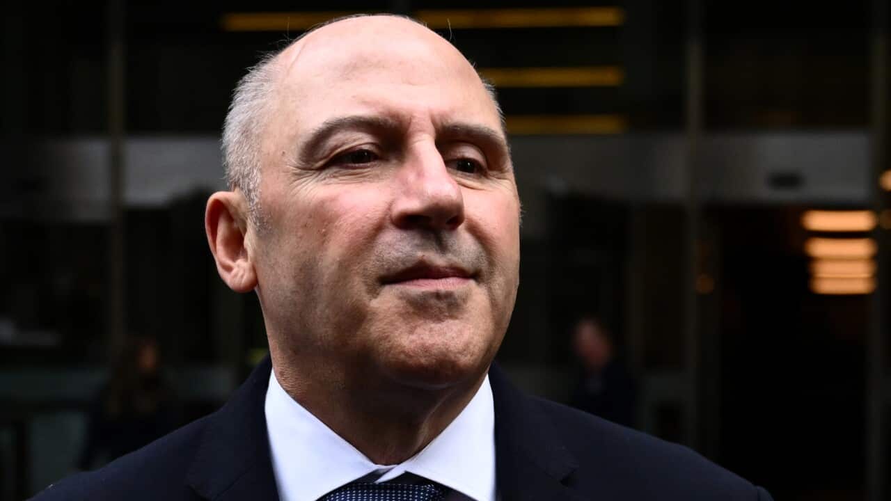 A man in a black suit and tie.