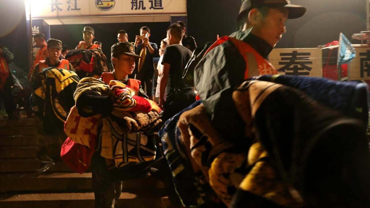 Rescuers carry supplies as they search for missing passengers of a capsized tourist ship in Jianli, Hubei province, China, 02 June 2015. (EPA/WU HONG)