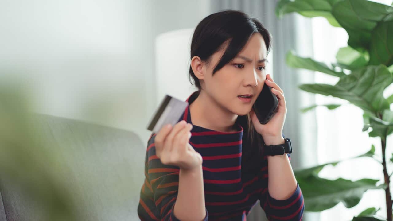 Asian woman talking on smartphone with call center of bank client support operator about problem with shopping and paying online.