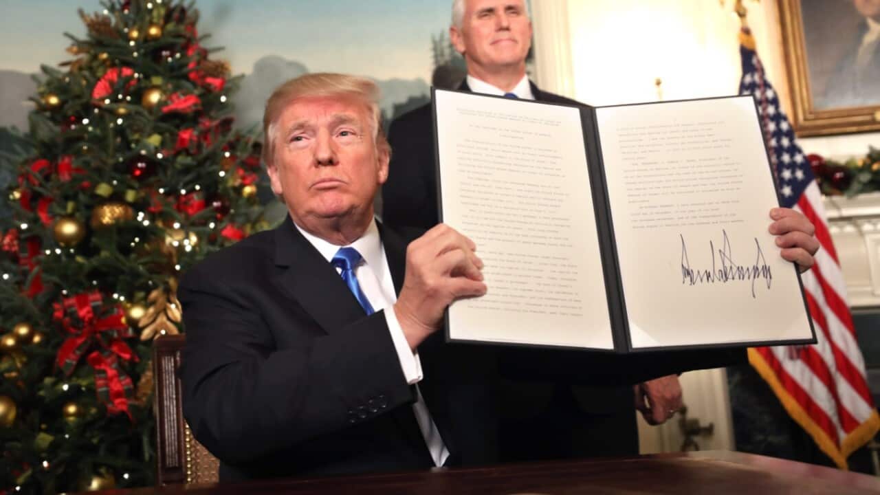 US VP Mike Pence (R) watches as US President Donald J. Trump (L) holds up his proclamation about his controversial decision to recognise Jerusalem