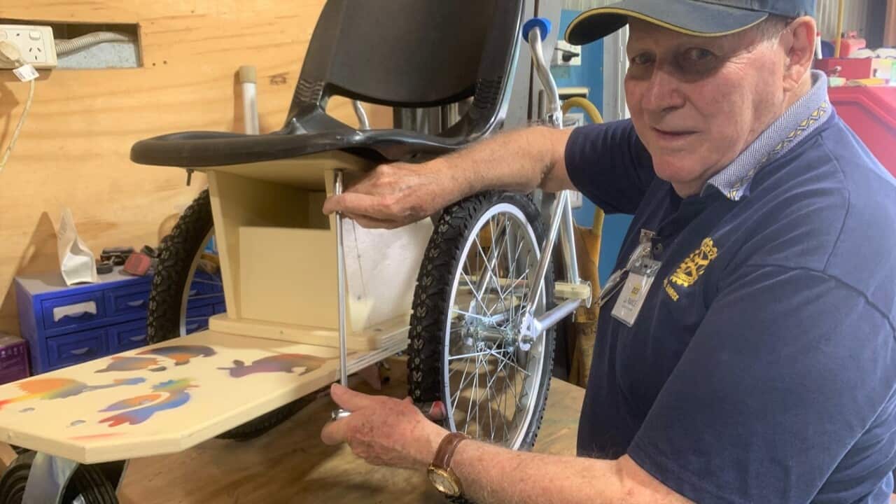 Inventor Des La Rance with a wheelchair made from repurposed bicycles.