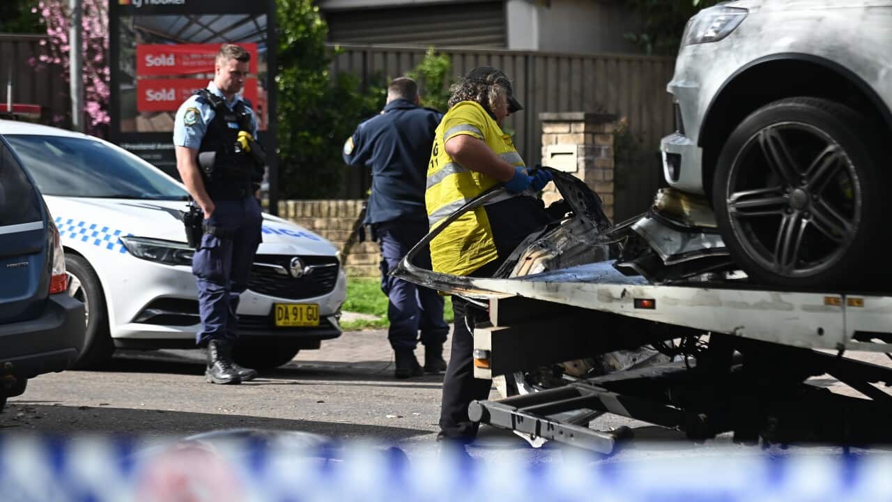 Police remove a vehicle from a suburban street.