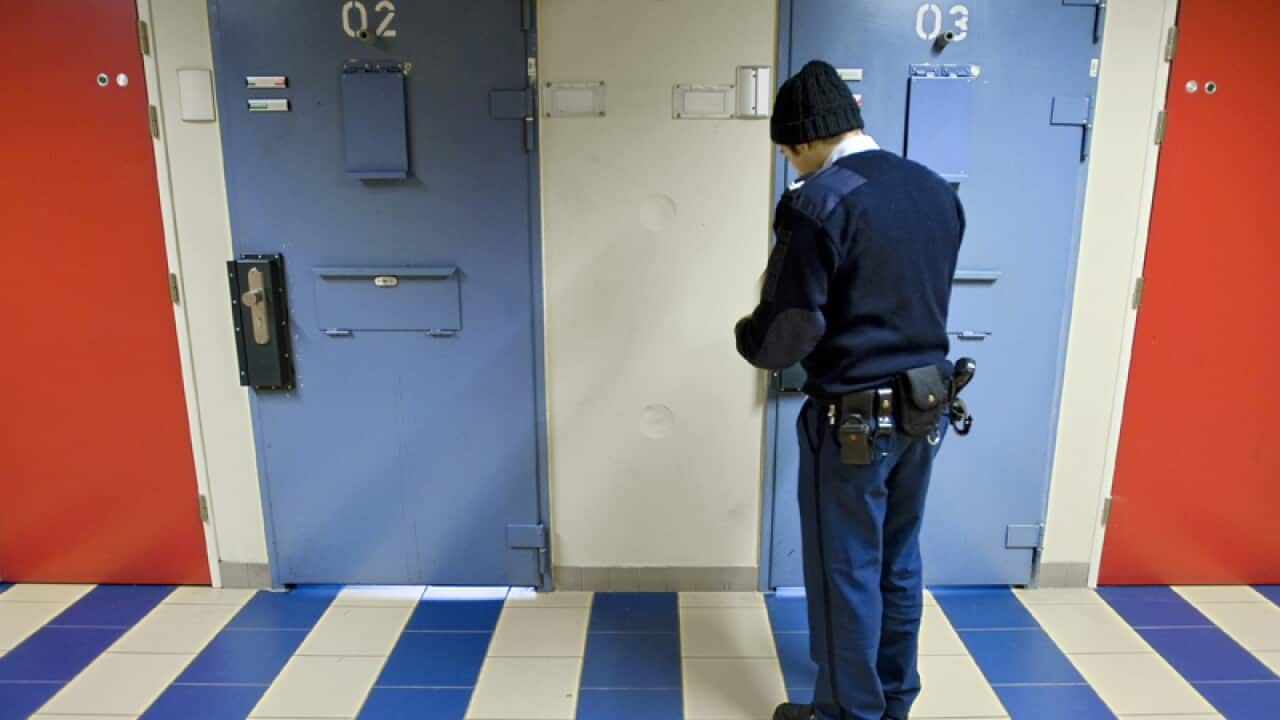 A jailer checks a cell