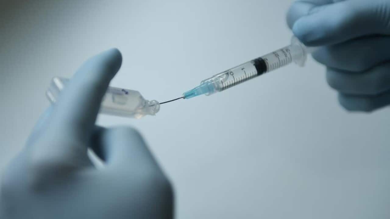 A stock image of a doctor drawing fluid into a syringe.