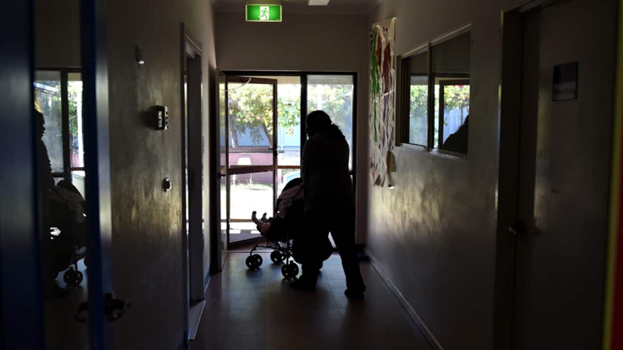 A mother pushes a pram at a women's shelter in Alice Springs