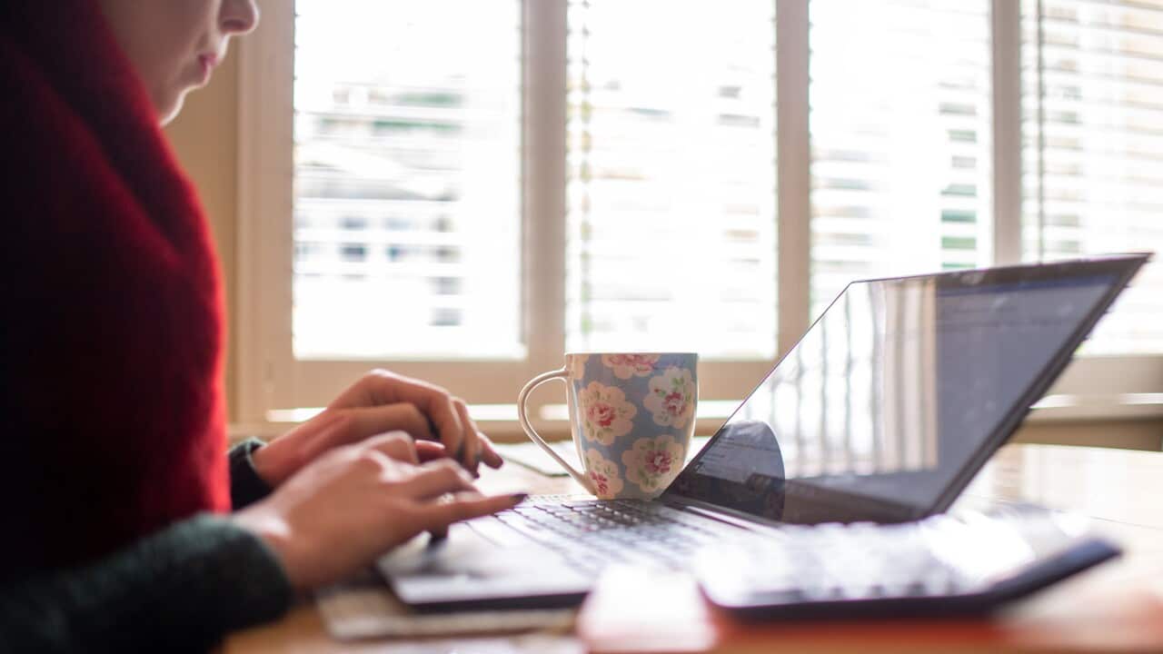 A worker connected on a laptop in their remote office