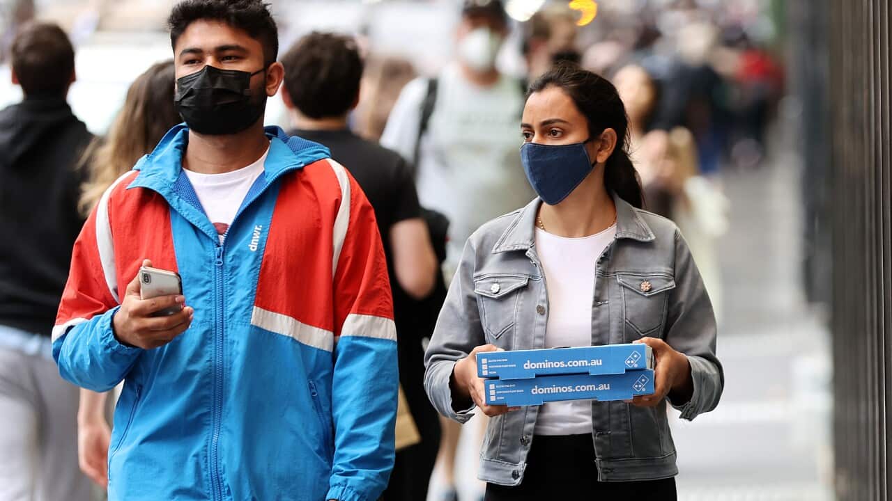 People wearing face masks are seen walking in Melbourne.