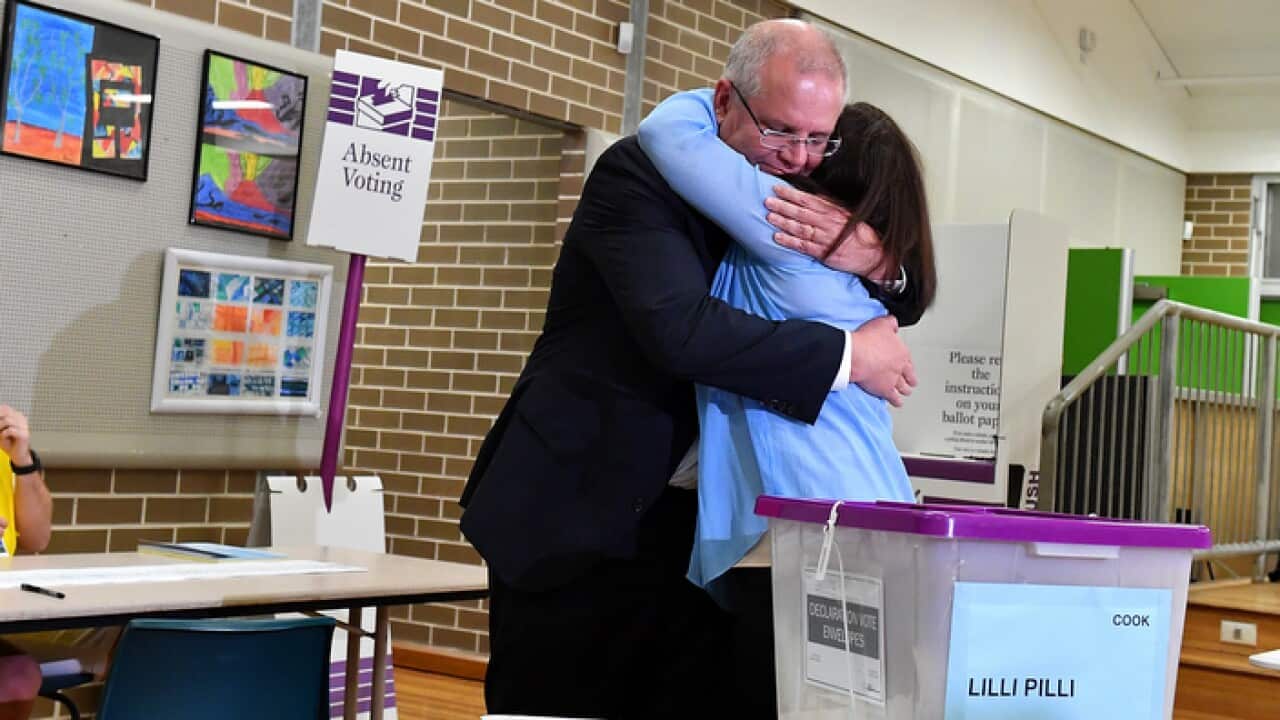 Australian Prime Minister Scott Morrison reacts after casting his vote alongside wife Jenny, on Election day
