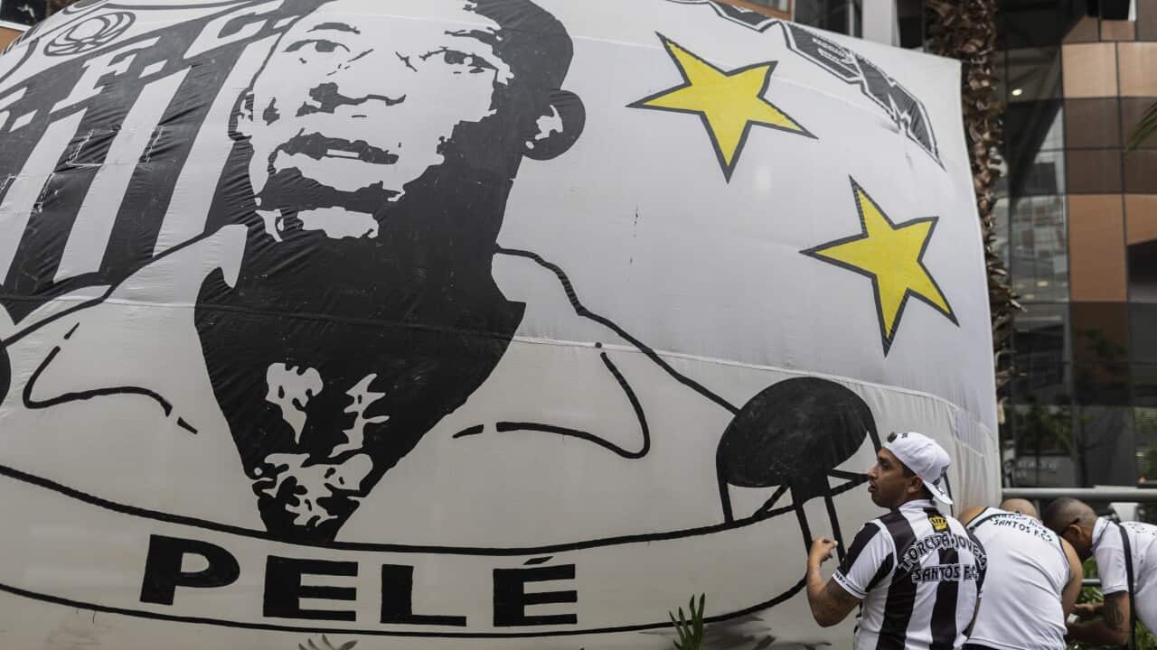 Pele fans stand in front of a blow-up Pele image in Sao Paulo, Brazil