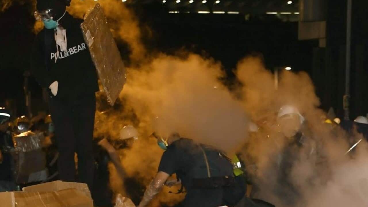 Protesters try to run away as police fire tear gas at them