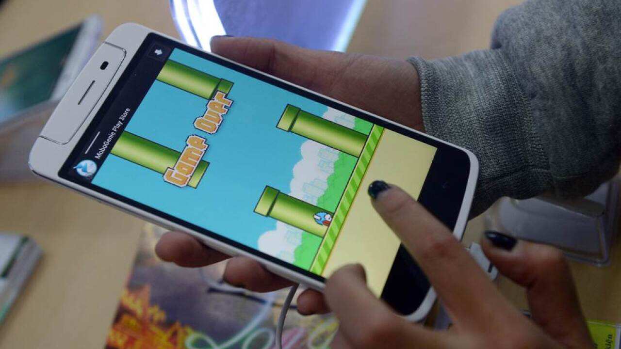 An employee plays the game Flappy Bird at a smartphone store in Hanoi on February 10, 2014.