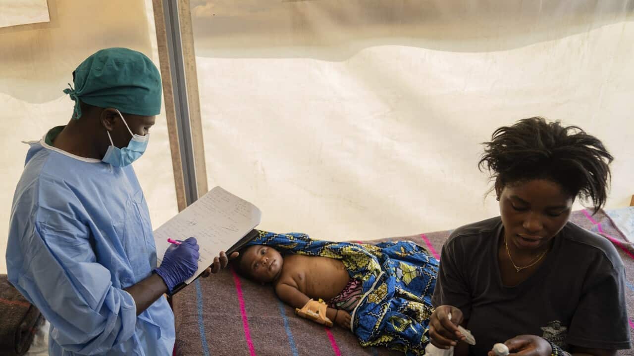 A health worker attends to a girl suffering from mpox, at a treatment centre in Munigi, eastern Congo