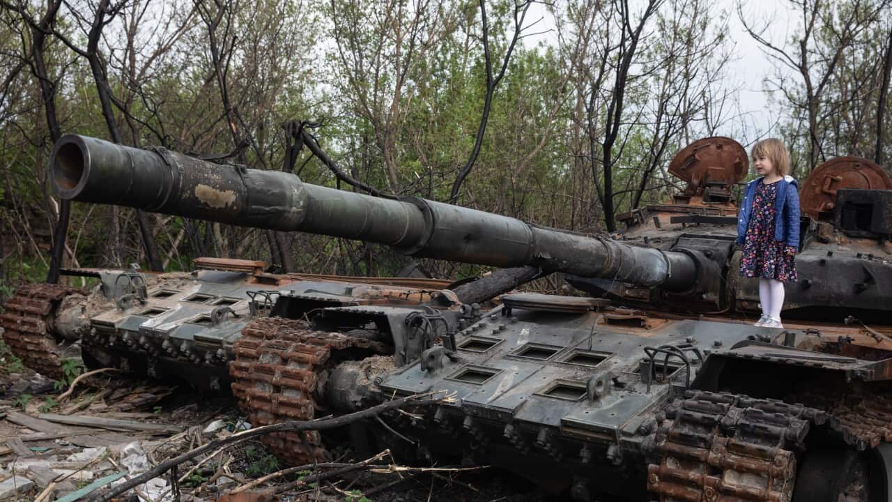A girl stands on the tower of a destroyed Russian tank near Makariv village, Kyiv region