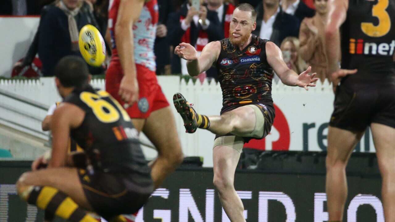 Jarryd Roughead of the Hawks (2nd right) scores the match winning goal