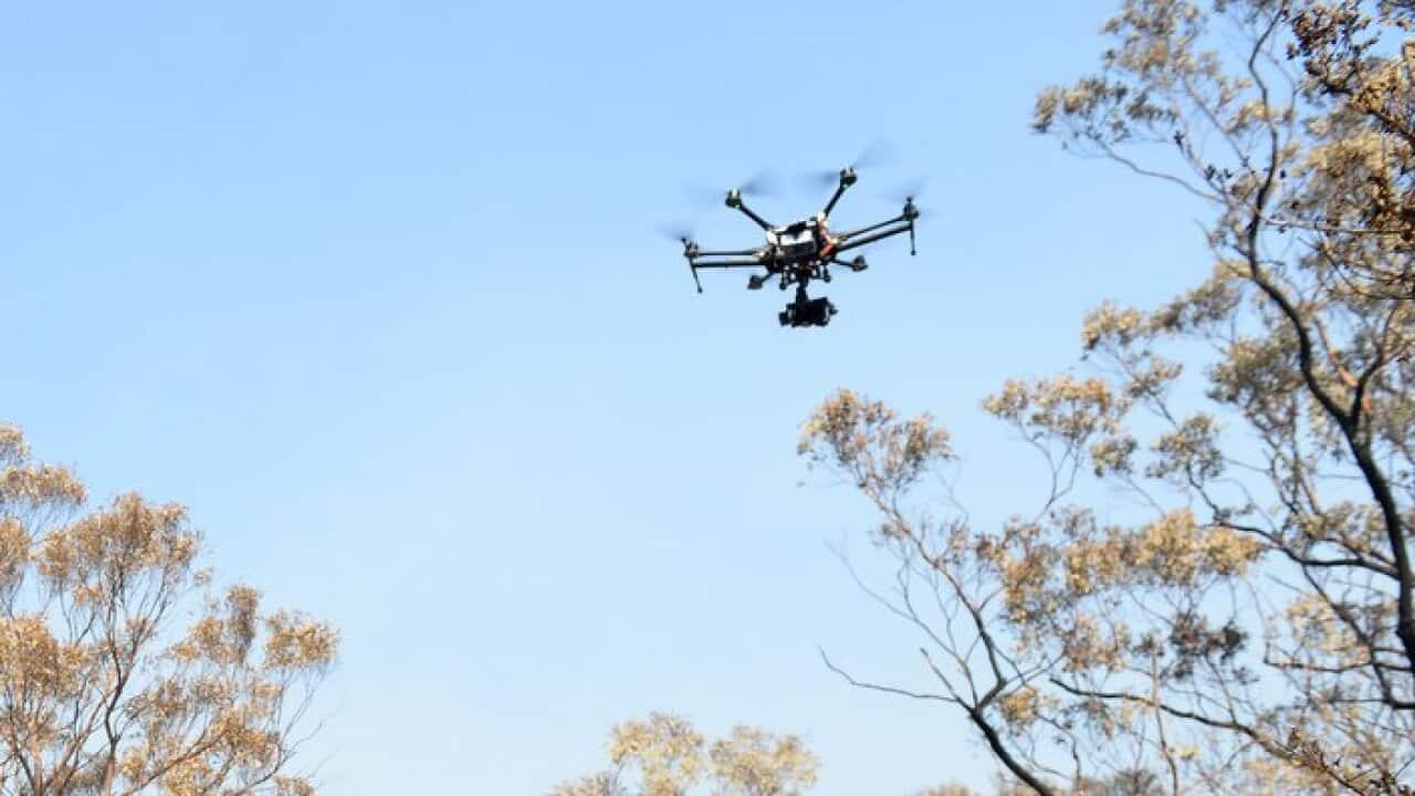 Tony Driver from the High Alpha media team operates a hexacopter camera drone over houses burnt by bushfire at Winmalee, in the Blue Mountains, west of Sydney, Friday, Oct. 25, 2013. (AAP Image/Dan Himbrechts) NO ARCHIVING