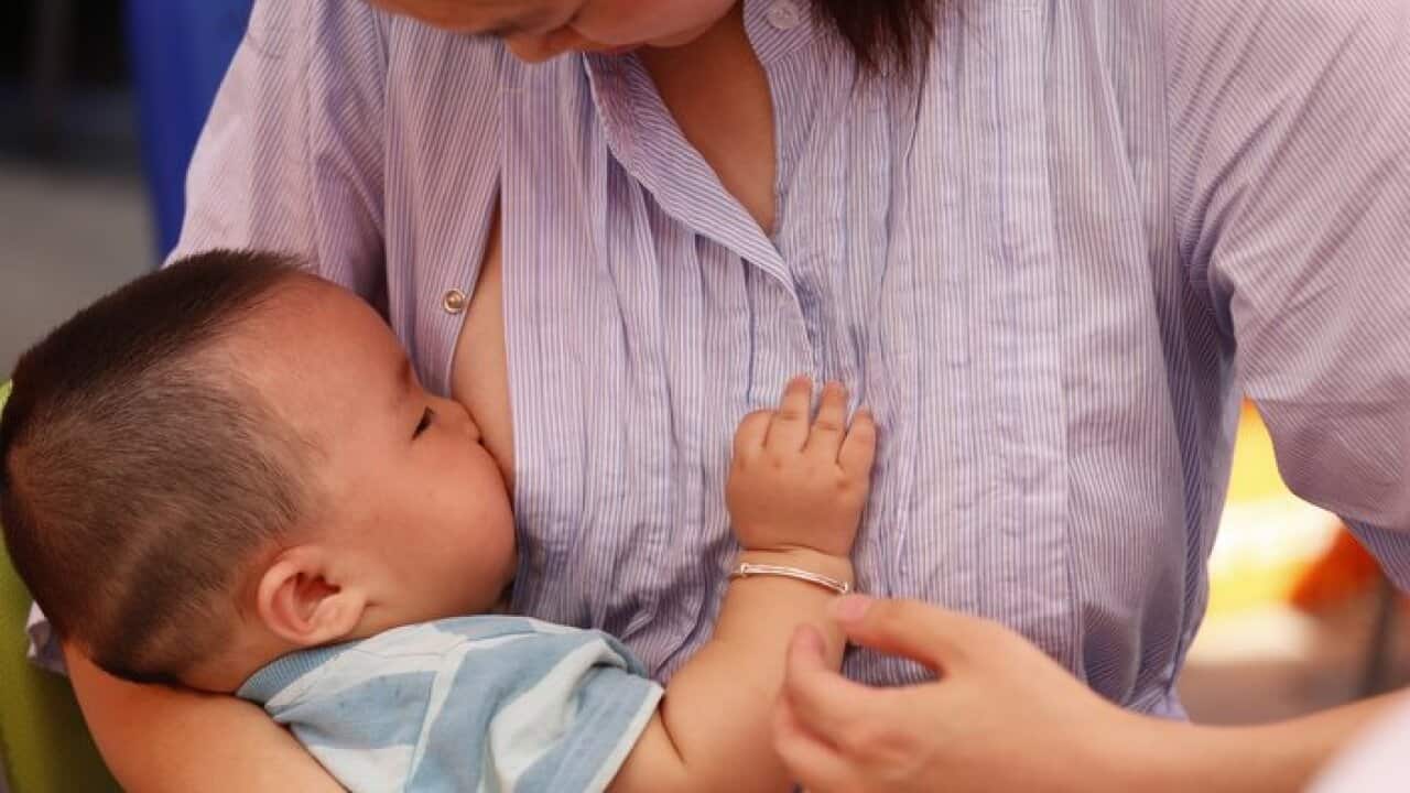 A mother breast-feeds her baby during a flash mob event to promote breast-feeding in Wuhan city, central Chinas Hubei province, 3 August 2013.
