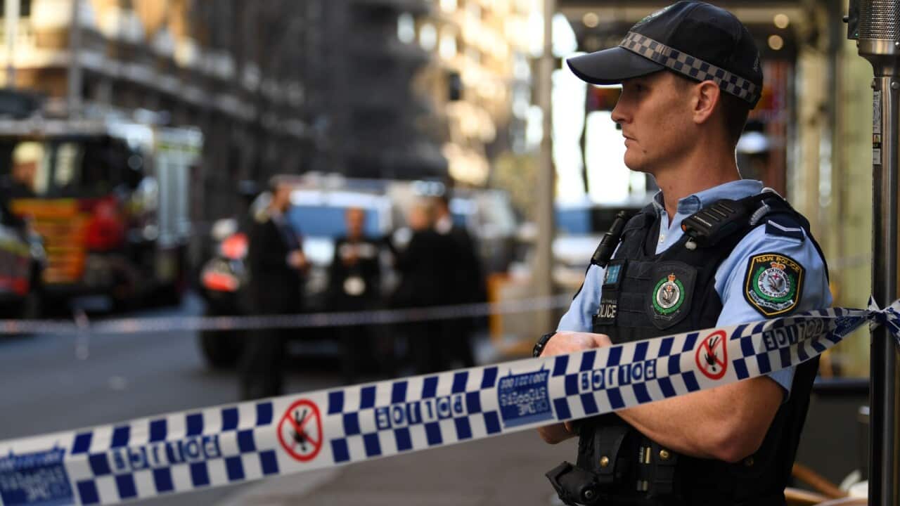 A policeman stands by a roped off crime scene
