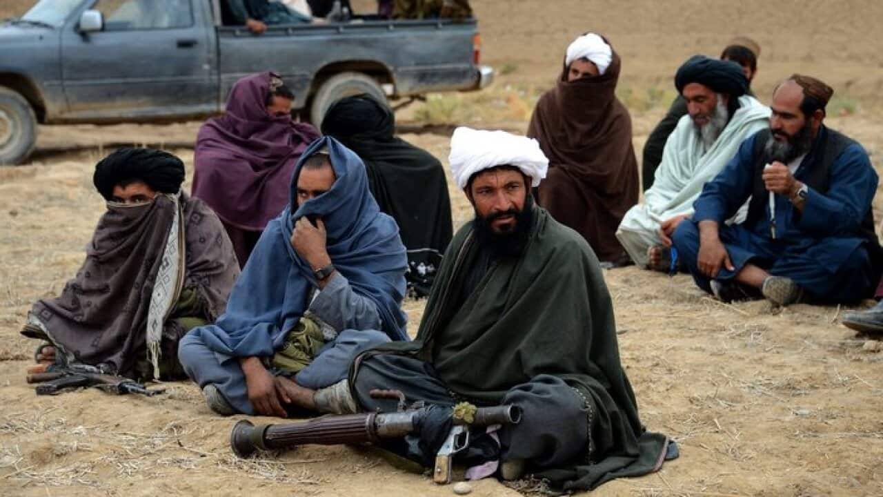 Afghan Taliban fighters listen to Mullah Mohammad Rasool Akhund
