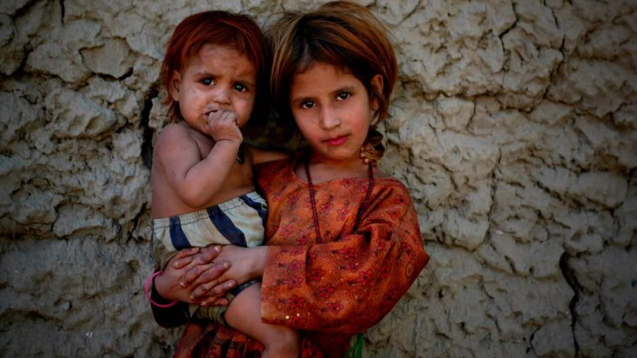 Zubaida, an Afghan girl holds her younger siste