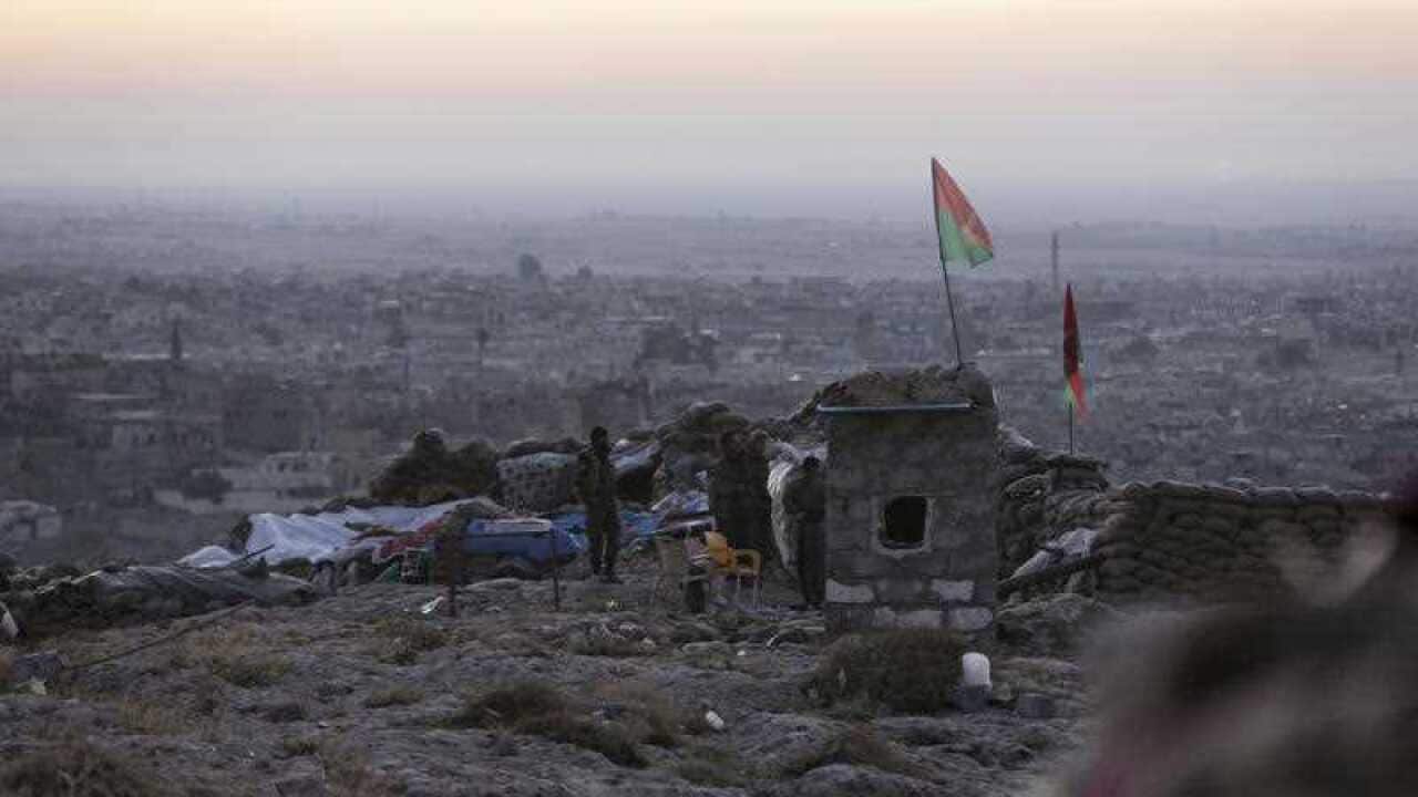 Kurdish fighters watch in the early morning as they fight against the Islamic State group in Sinjar, Iraq. (AP)