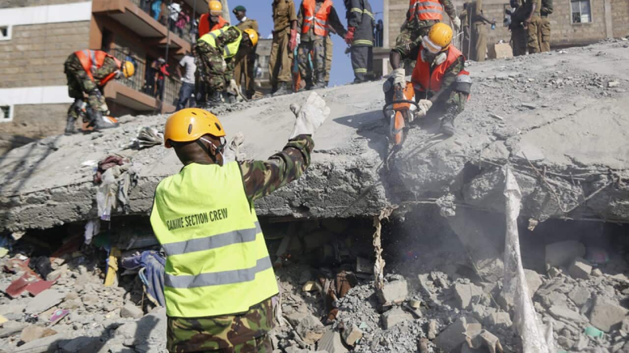 Rescue workers try to cut through concrete