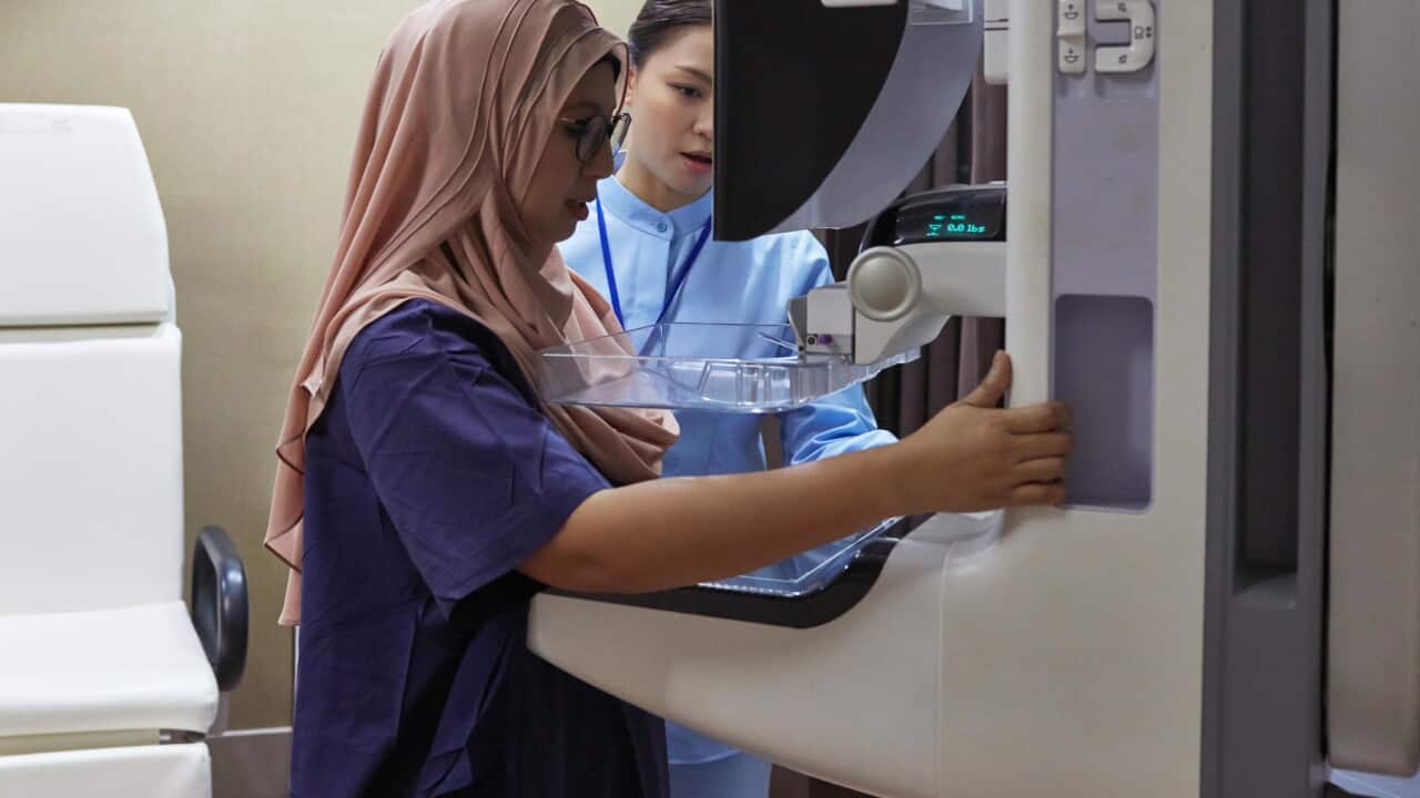 Nurse Assisting Patient During Mammography Exam