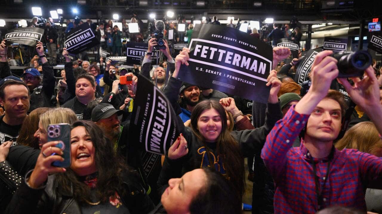 A crowd cheering. Some are holding signs that read: "FETTERMAN: Every County. Every Vote."