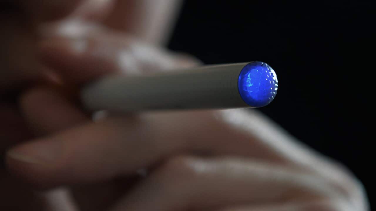 A person smokes an e-cigarette