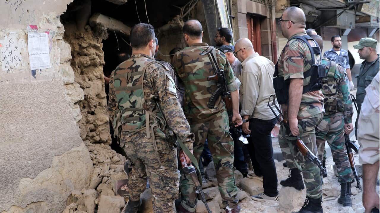 ecurity personnel inspects and cordon the area surrounding the Police Command's building in Damascus, Syria.