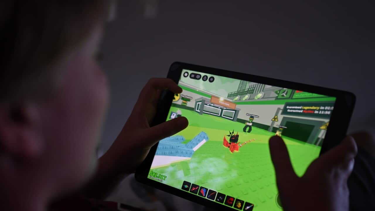 A 12-year-old boy plays a Roblox game on his device in Sydney - AAP.