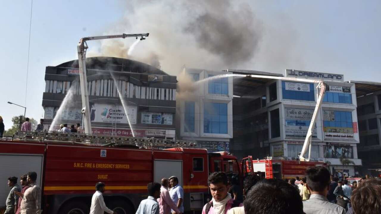 Indian firefighters work to douse fire at a tutoring center in Surat, Gujarat, 24 May 2019.