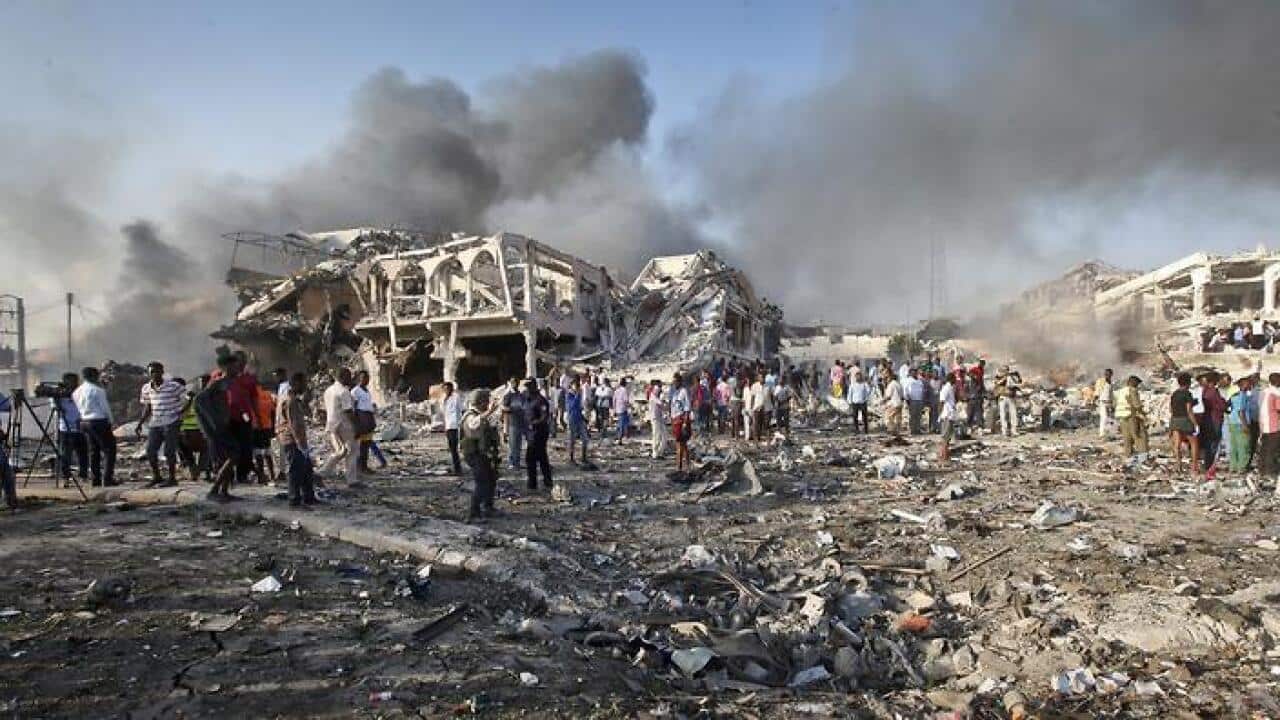 Somalis gather and search for survivors by destroyed buildings at the scene of a blast in the capital Mogadishu